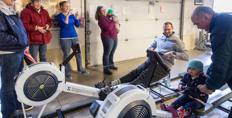 Crew Alumni and families using rowing machines